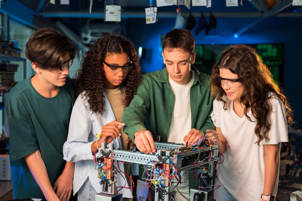 High school students assembling a robot in a workshop