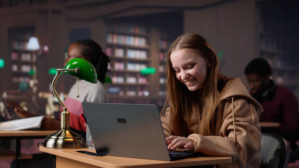 Teenager coding on a laptop in a focused environment