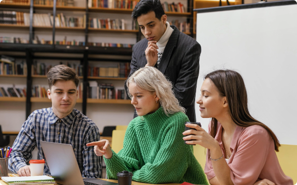 Group of students collaborating around a laptop